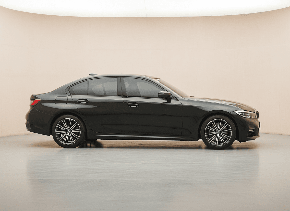 Dark grey BMW 3 Series M Sport saloon in a pale studio
